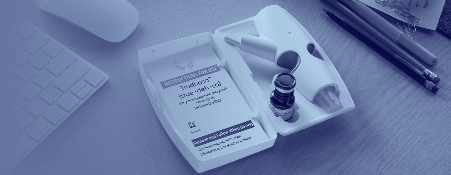 Image of an open Trudhesa® Precision Olfactory Delivery (POD®) package showing the POD and vial laying on a wood table next to pens